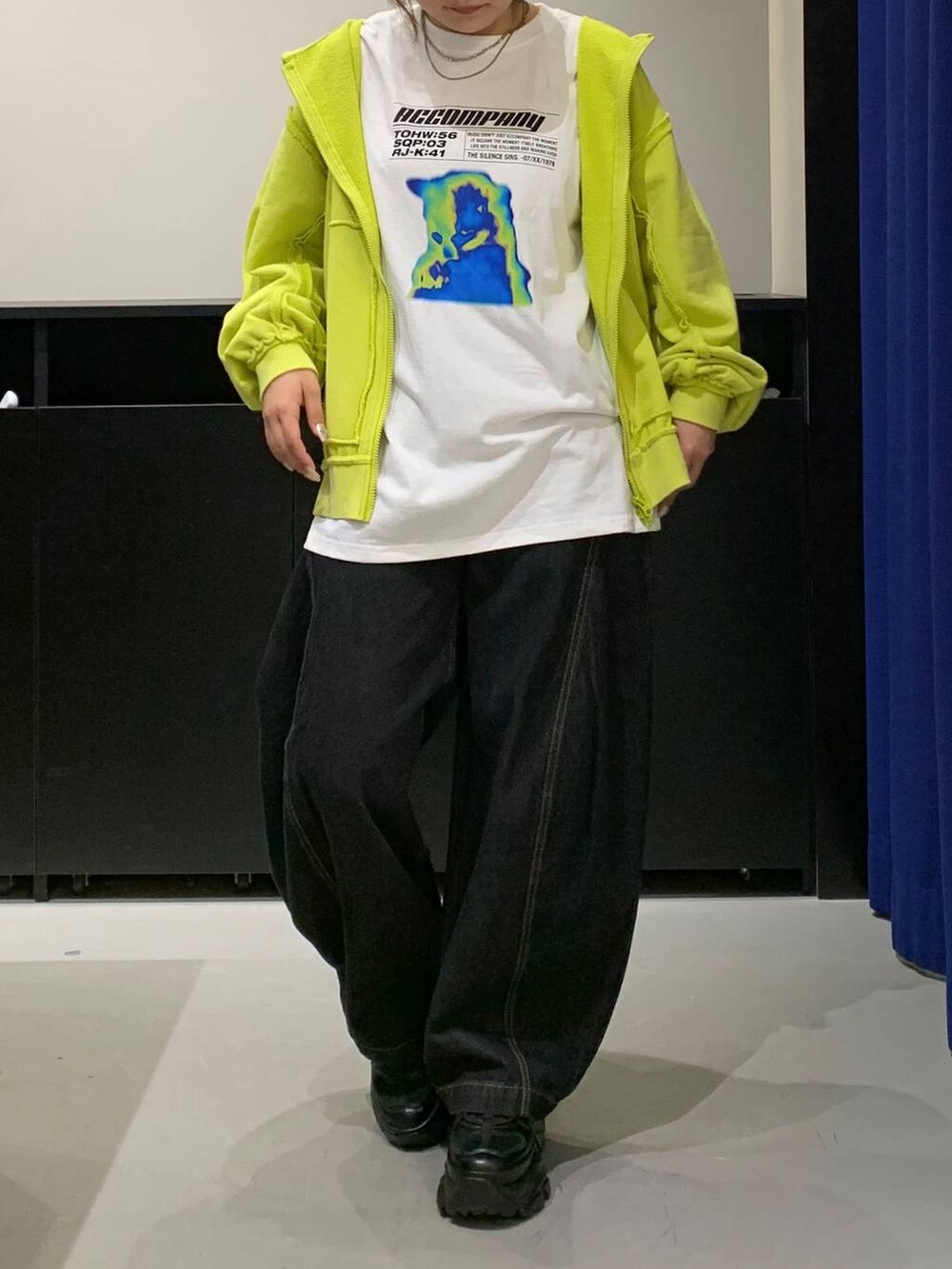 ブラック系のスニーカー、ブラック系のデニムパンツ、ホワイト系のTシャツ/カットソーを着用したレディースの秋コーディネートの2枚目の写真