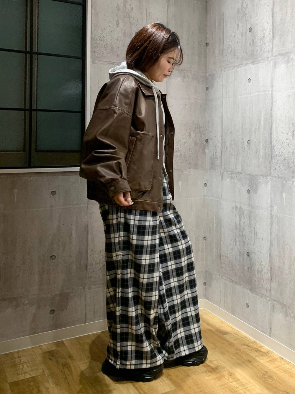 ブラック系のスニーカー、ブラウン系のブルゾン、グレー系のパーカーを着用したレディースの秋コーディネートの4枚目の写真