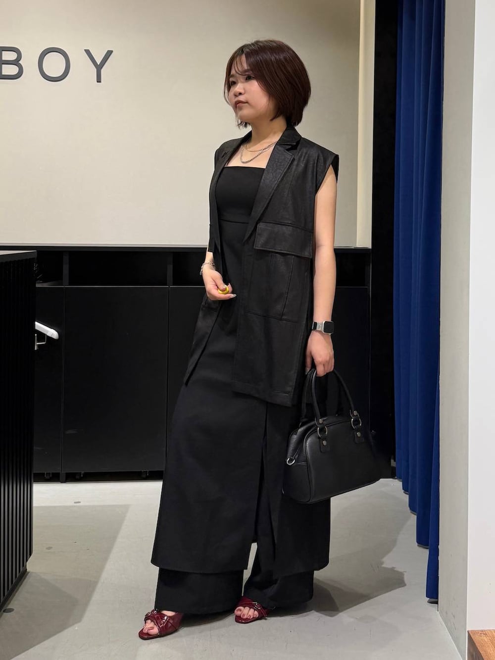 ホワイト系のキャミソール、レッド系のサンダル、ブラック系のワンピースを着用したレディースの夏コーディネートの6枚目の写真