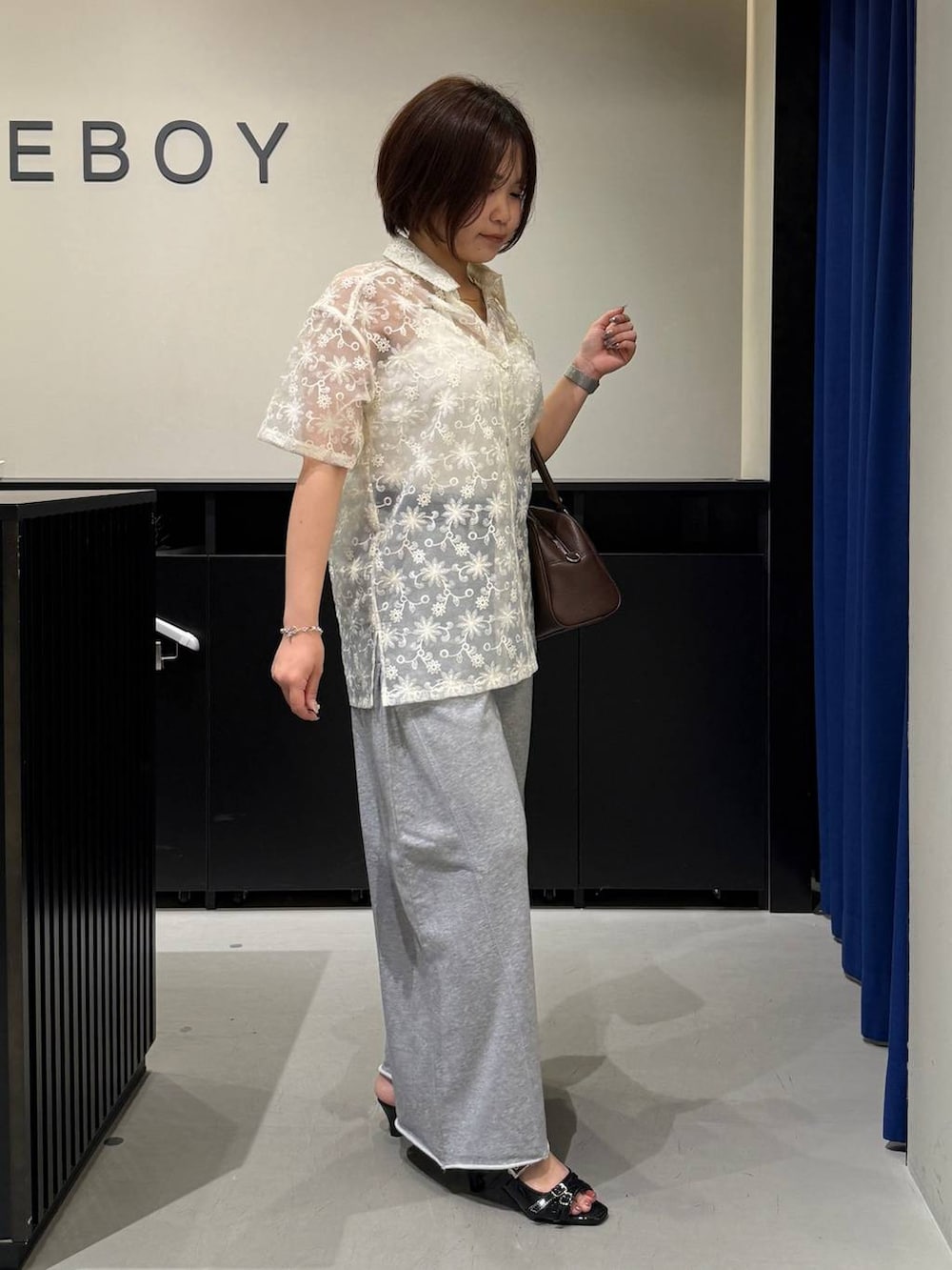 ホワイト系のキャミソール、ブラック系のサンダル、ブラウン系のショルダーバッグを着用したレディースの夏コーディネートの3枚目の写真