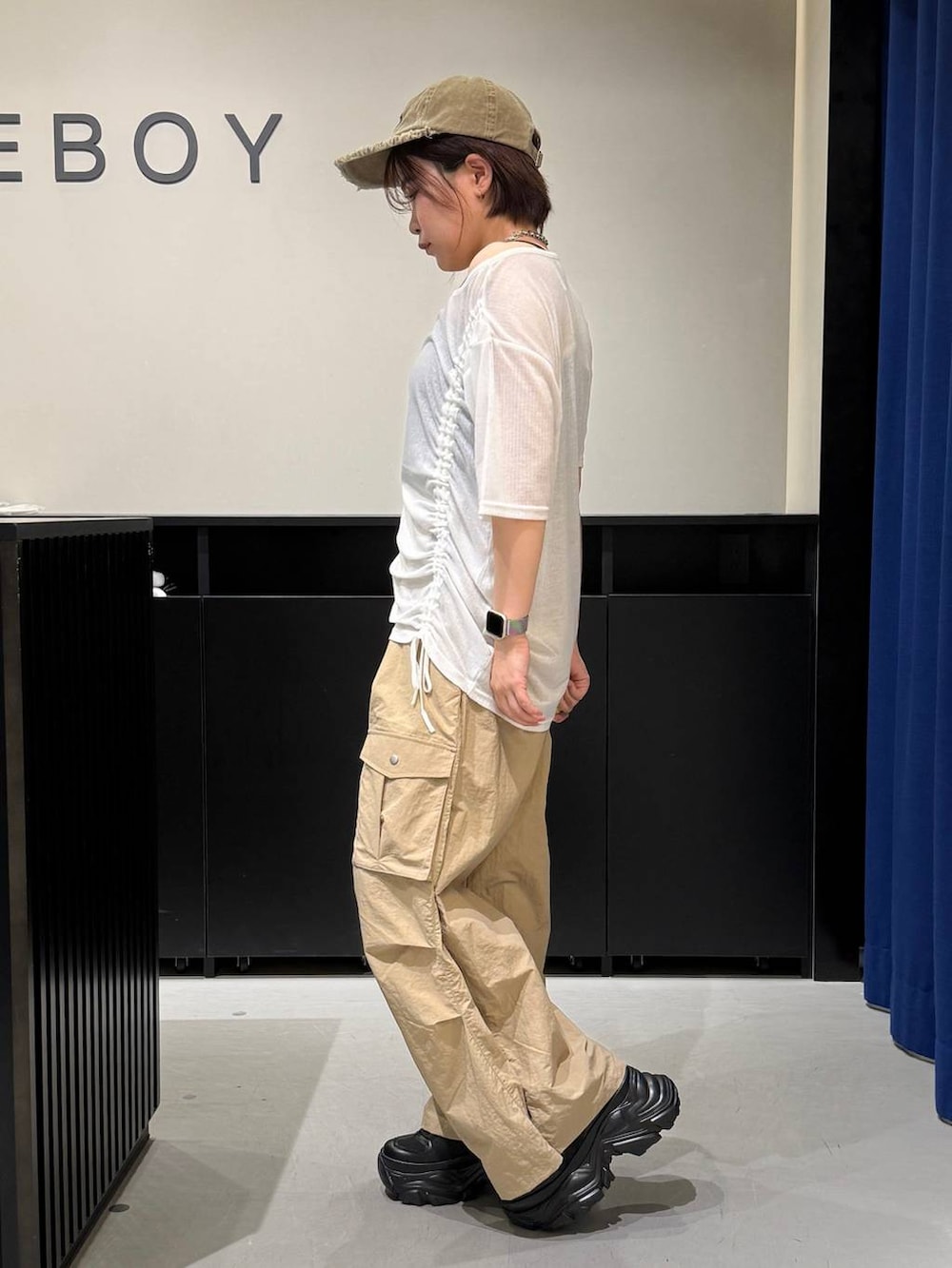 ブラック系のスニーカー、ベージュ系のカーゴパンツ、ホワイト系のTシャツ/カットソーを着用したレディースの夏コーディネートの5枚目の写真