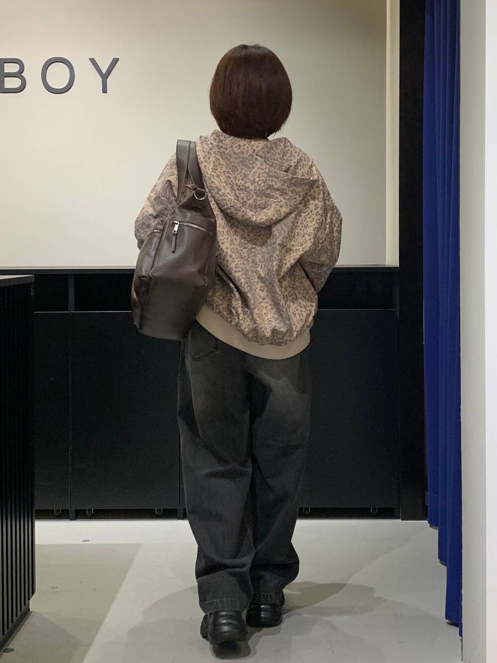 ブラック系のスニーカー、ブラウン系のボストンバッグ、その他のブルゾンを着用したレディースの秋コーディネートの5枚目の写真