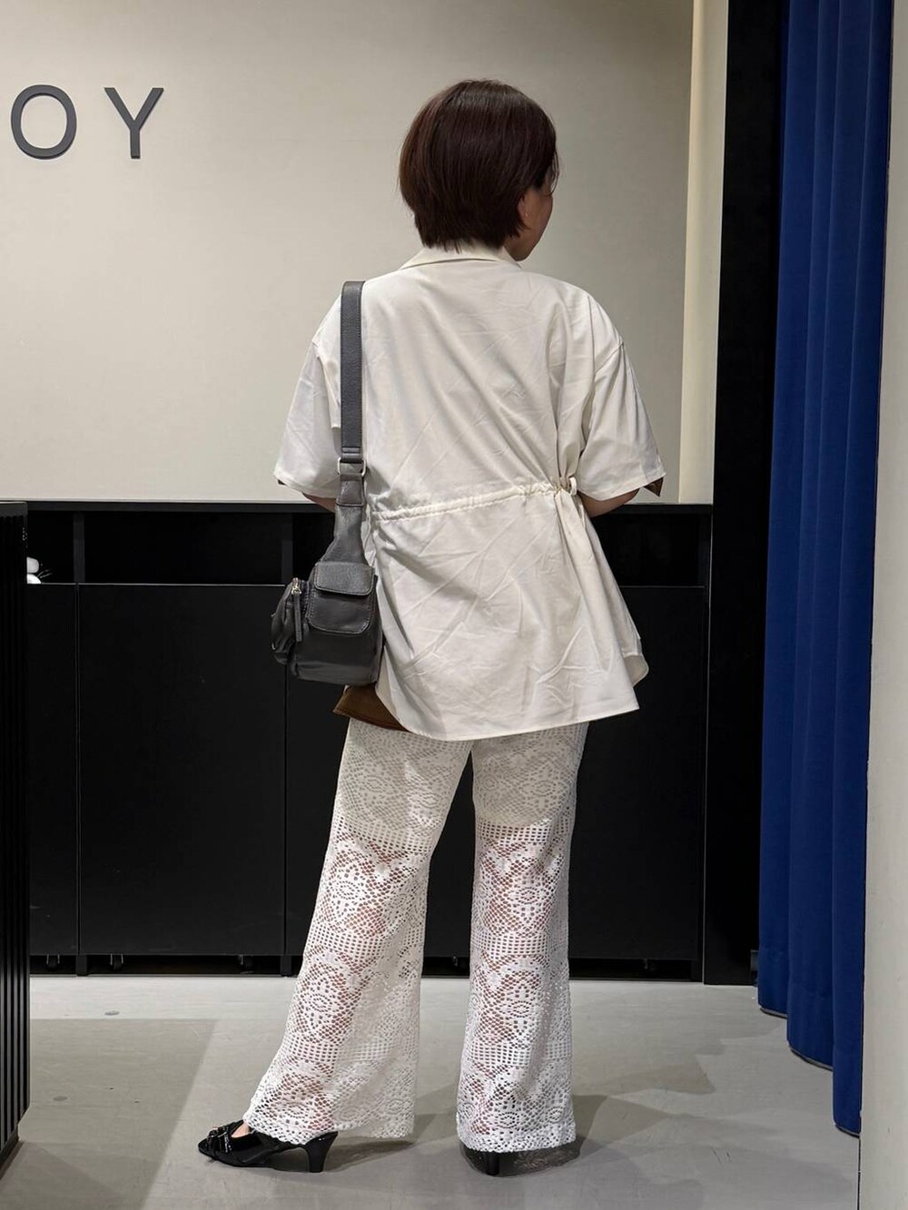 ブラック系のショルダーバッグ、ブラック系のサンダル、ホワイト系のTシャツ/カットソーを着用したレディースの夏コーディネートの6枚目の写真