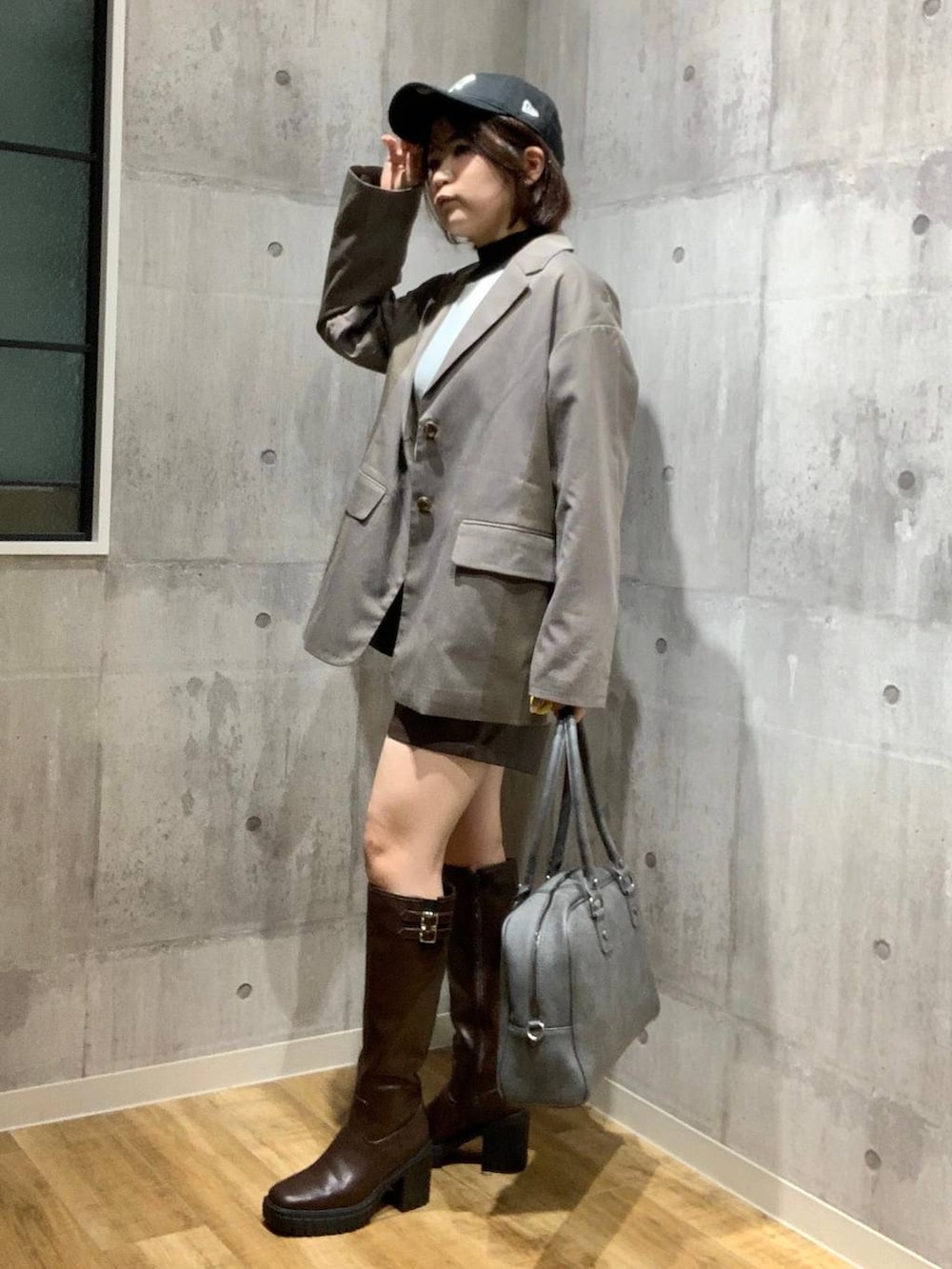 グレー系のボストンバッグ、ブラウン系のテーラードジャケット、ホワイト系のニット/セーターを着用したレディースの秋コーディネートの7枚目の写真