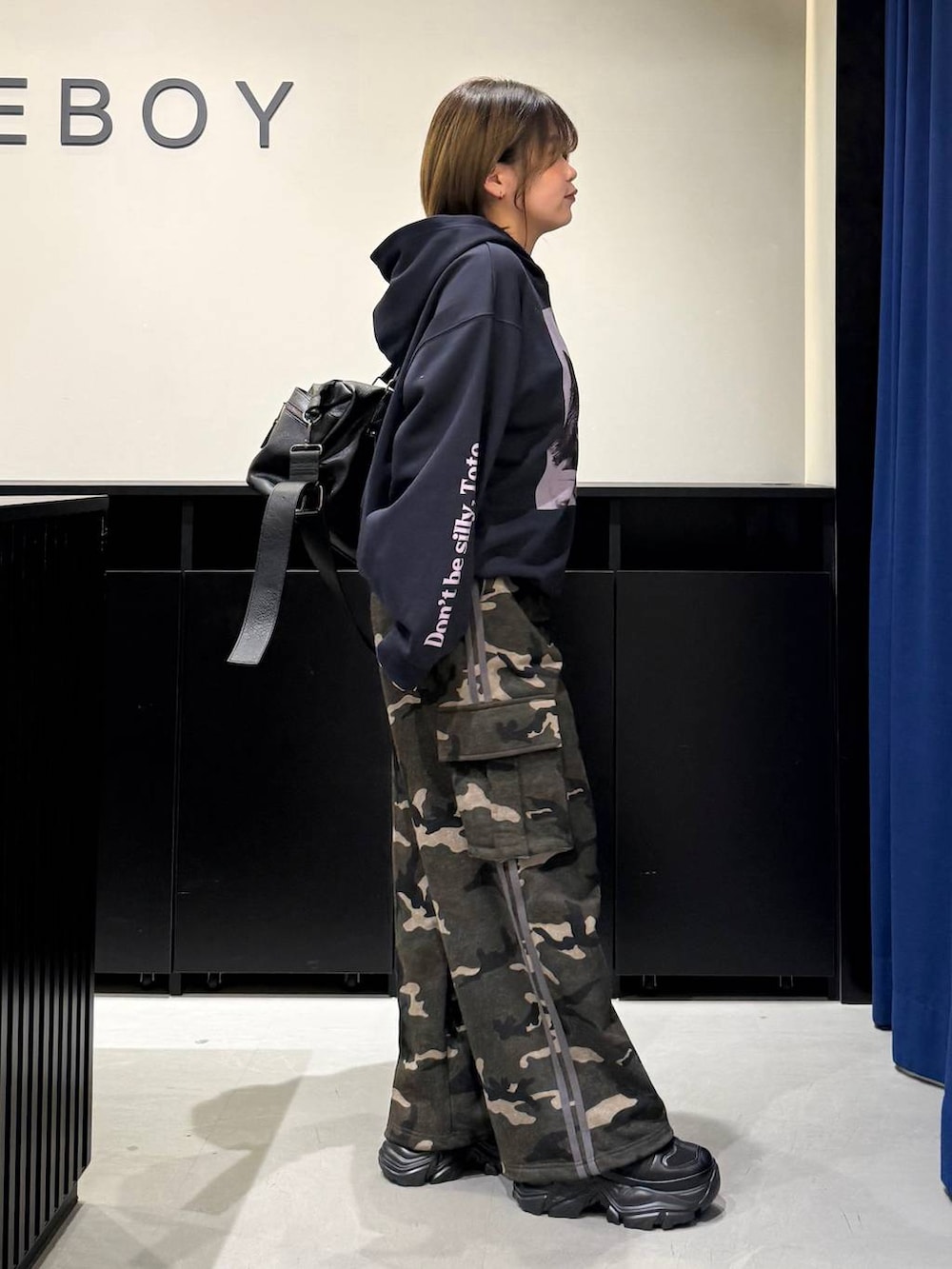 ブラック系のスニーカー、ブラック系のボストンバッグ、グリーン系のスウェットパンツを着用したレディースの冬コーディネートの5枚目の写真