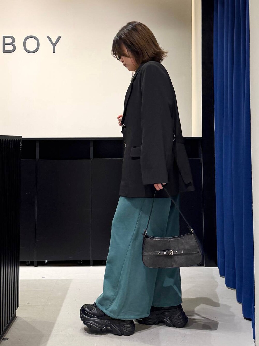 ブラック系のスニーカー、ホワイト系のニット/セーター、ブラック系のテーラードジャケットを着用したレディースの冬コーディネートの6枚目の写真