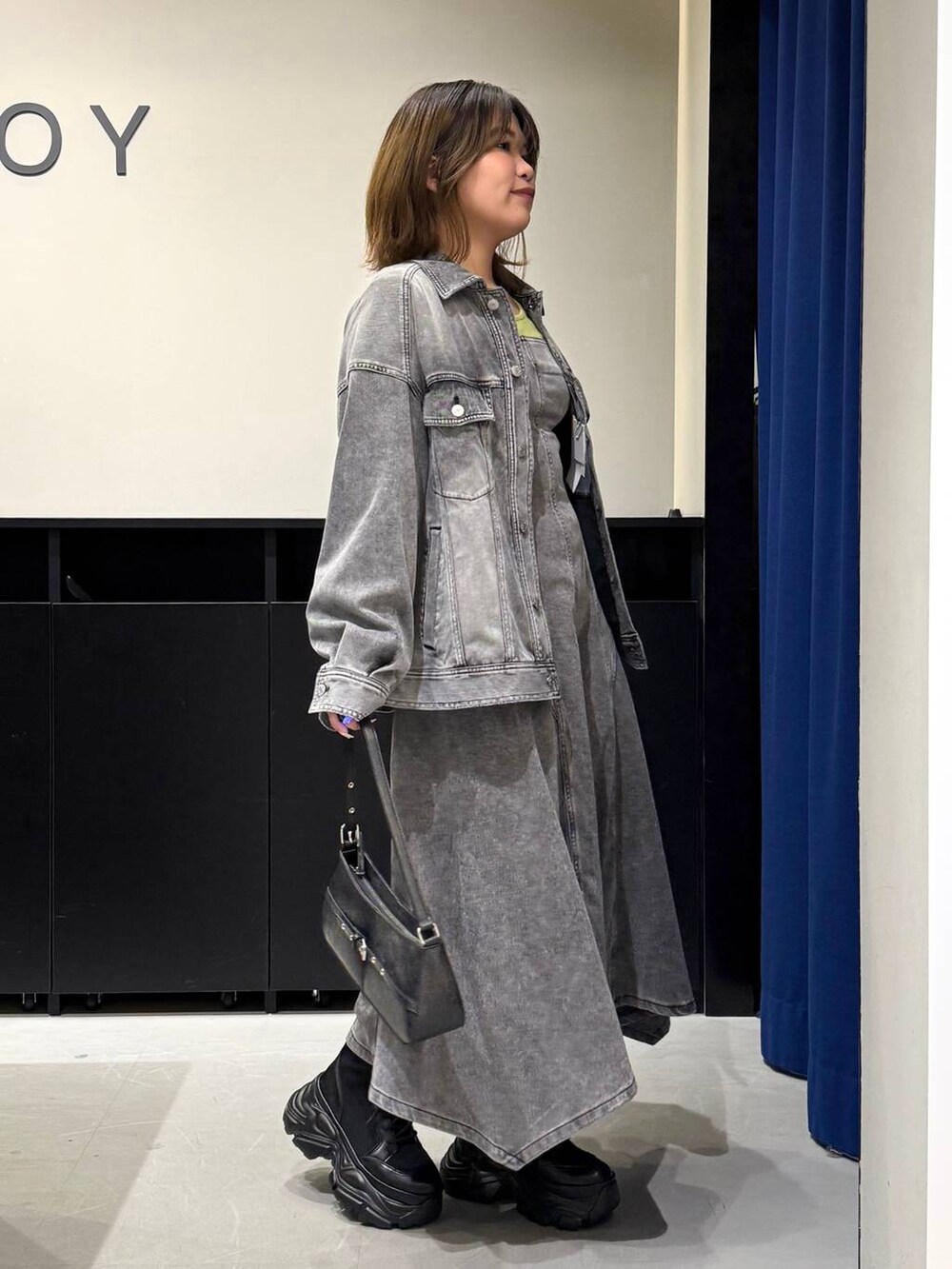 ブラック系のブーツ、ブラック系のハンドバッグ、ブラック系のブルゾンを着用したレディースの冬コーディネートの4枚目の写真