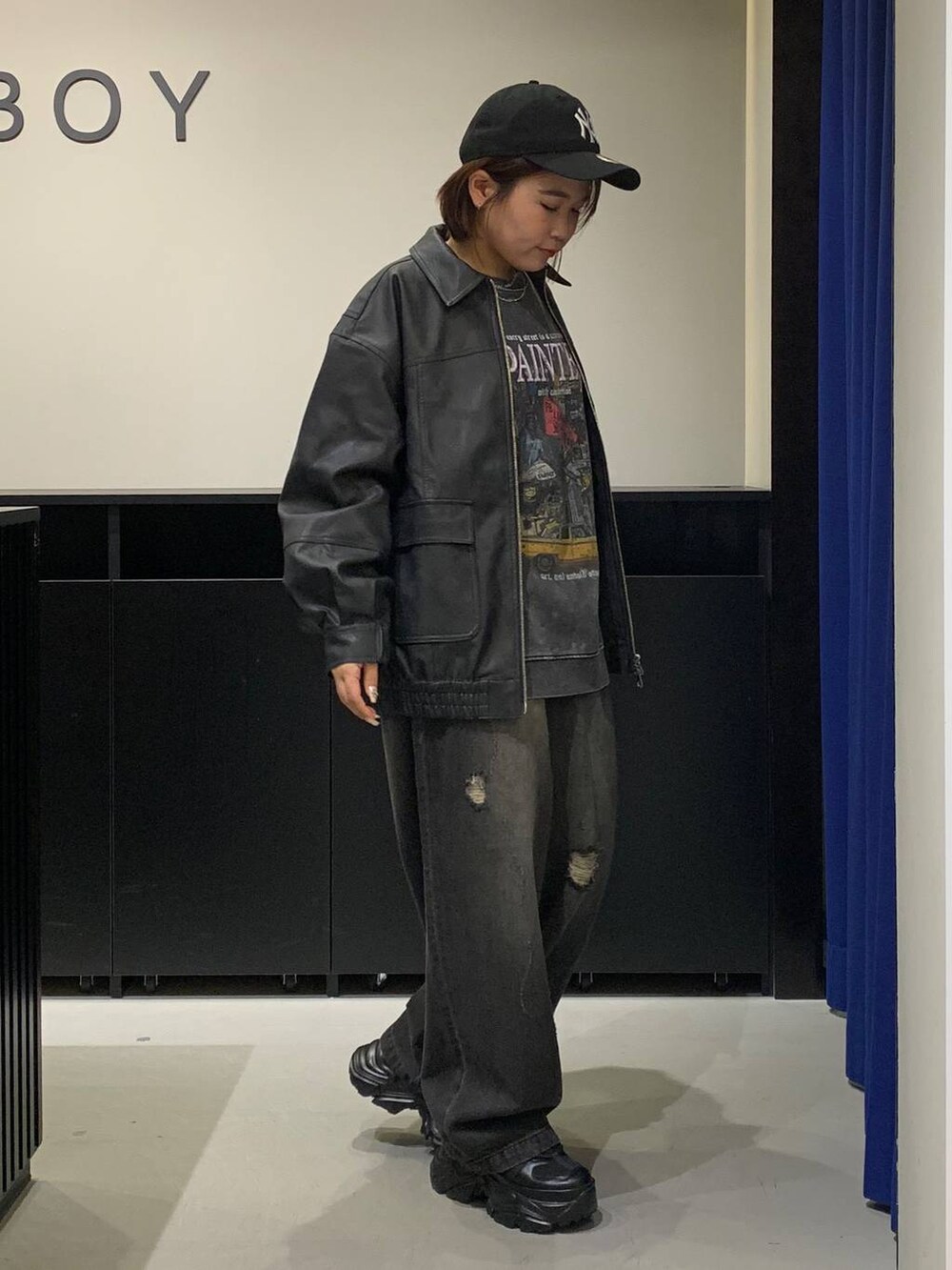 ブラック系のスニーカー、ブラック系のデニムパンツ、ブラック系のブルゾンを着用したレディースの秋コーディネートの3枚目の写真