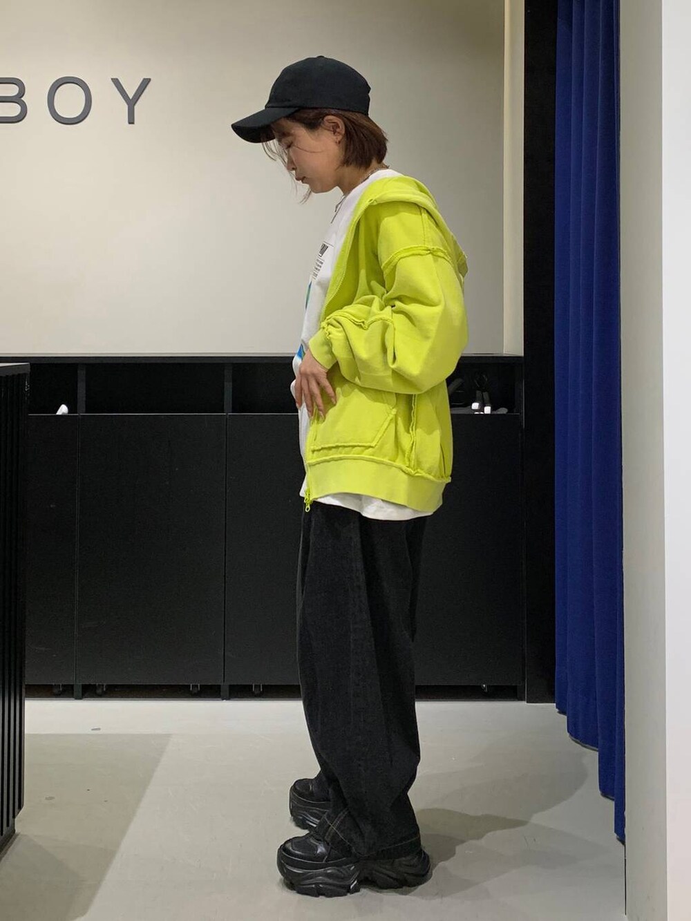 ブラック系のスニーカー、ブラック系のデニムパンツ、ホワイト系のTシャツ/カットソーを着用したレディースの秋コーディネートの6枚目の写真