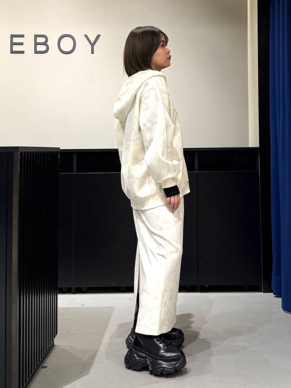 ブラック系のブーツ、ホワイト系のスカート、ホワイト系のパーカーを着用したレディースの冬コーディネートの4枚目の写真