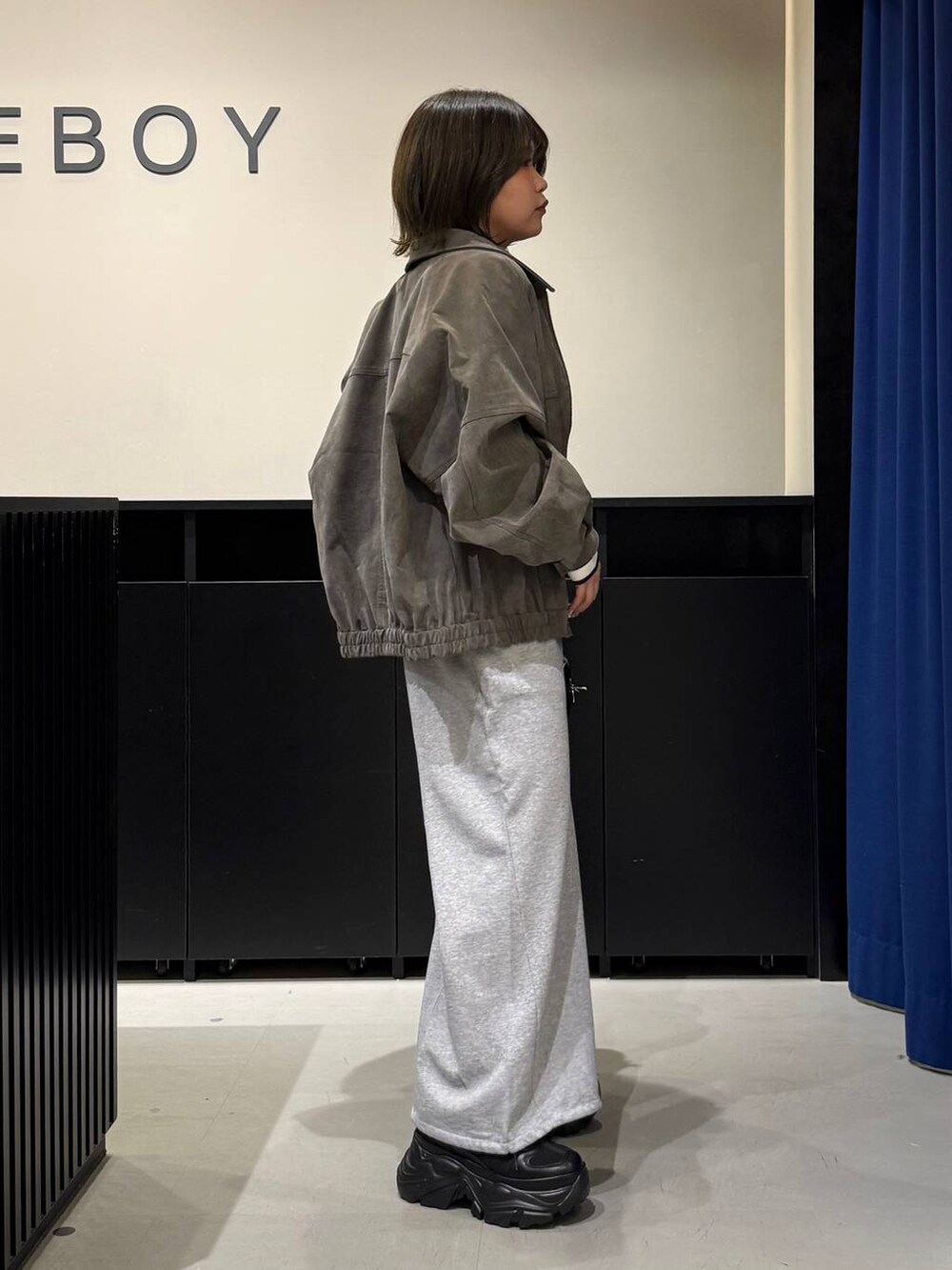 ブラック系のスニーカー、ブラック系のボストンバッグ、ホワイト系のニット/セーターを着用したレディースの冬コーディネートの4枚目の写真