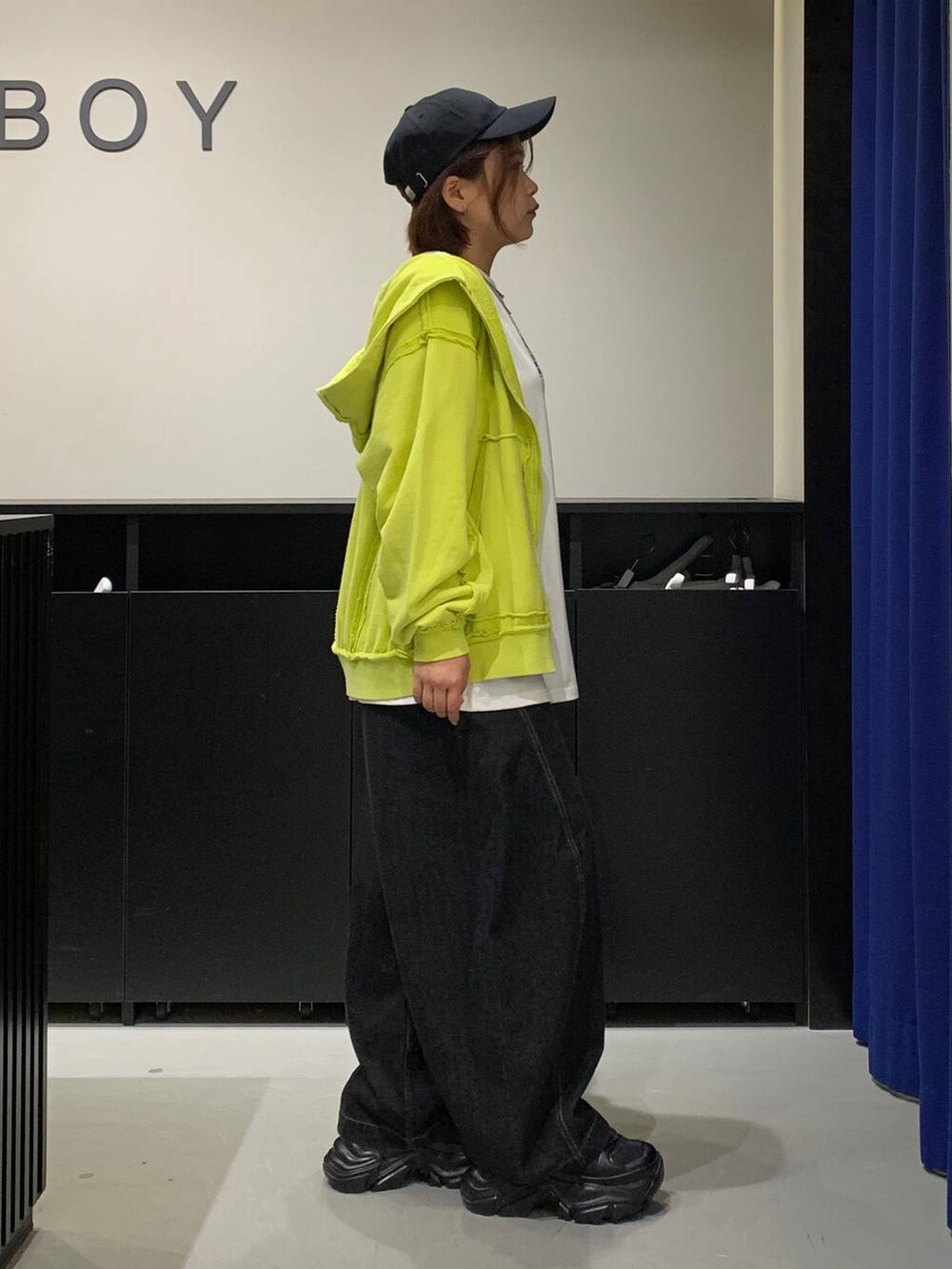 ブラック系のスニーカー、ブラック系のデニムパンツ、ホワイト系のTシャツ/カットソーを着用したレディースの秋コーディネートの4枚目の写真