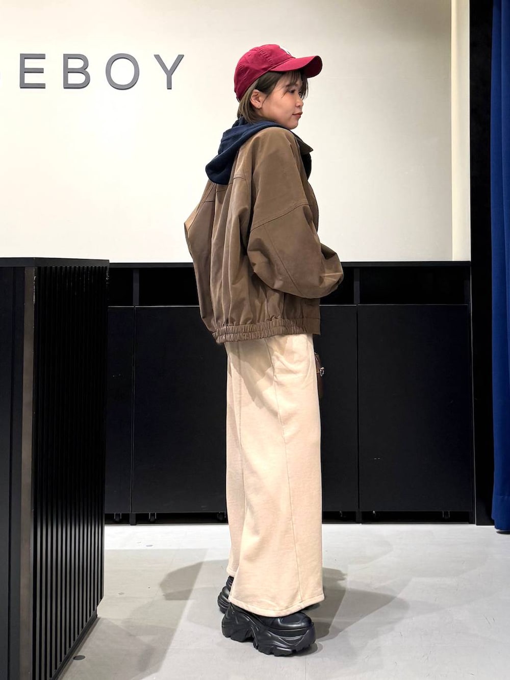 ブラック系のスニーカー、ブラウン系のボストンバッグ、ブルー系のパーカーを着用したレディースの冬コーディネートの4枚目の写真