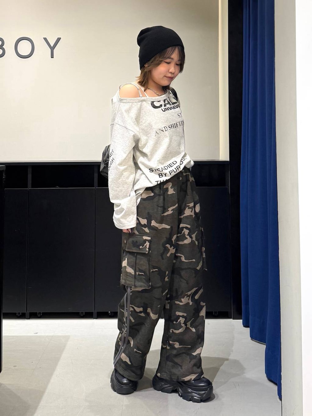 ブラック系のスニーカー、ホワイト系のキャミソール、ブラック系のショルダーバッグを着用したレディースの冬コーディネートの3枚目の写真