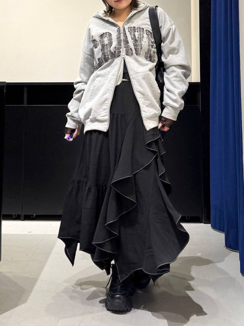 ブラック系のスニーカー、ブラック系のボストンバッグ、ブラック系のスカートを着用したレディースの冬コーディネートの2枚目の写真