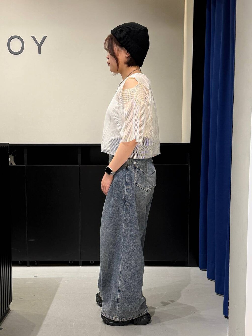 ブルー系のデニムパンツ、ブラック系のスニーカー、ホワイト系のTシャツ/カットソーを着用したレディースの夏コーディネートの4枚目の写真