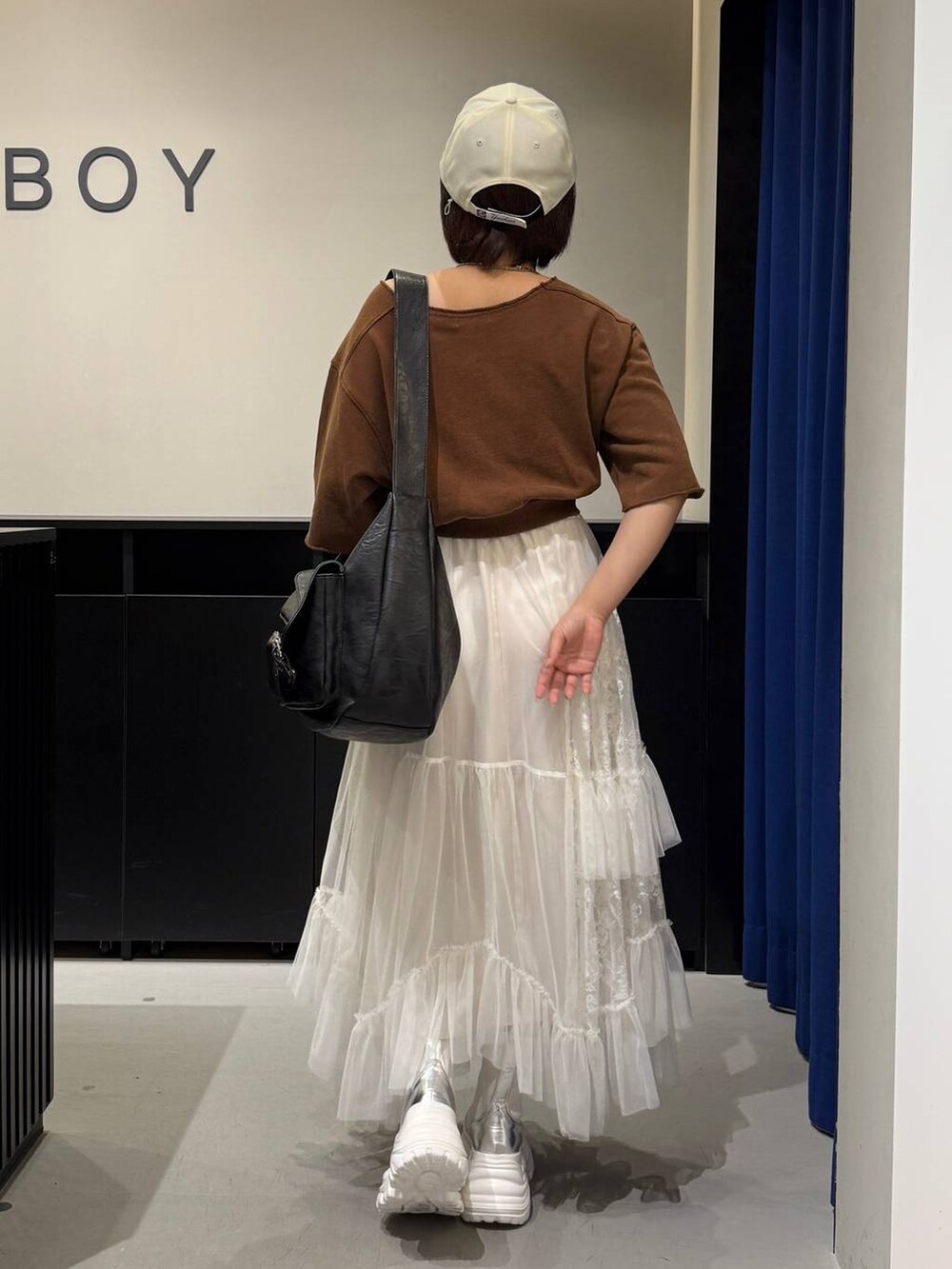 ホワイト系のブーツ、ブラウン系のTシャツ/カットソー、ブラック系のショルダーバッグを着用したレディースの夏コーディネートの5枚目の写真