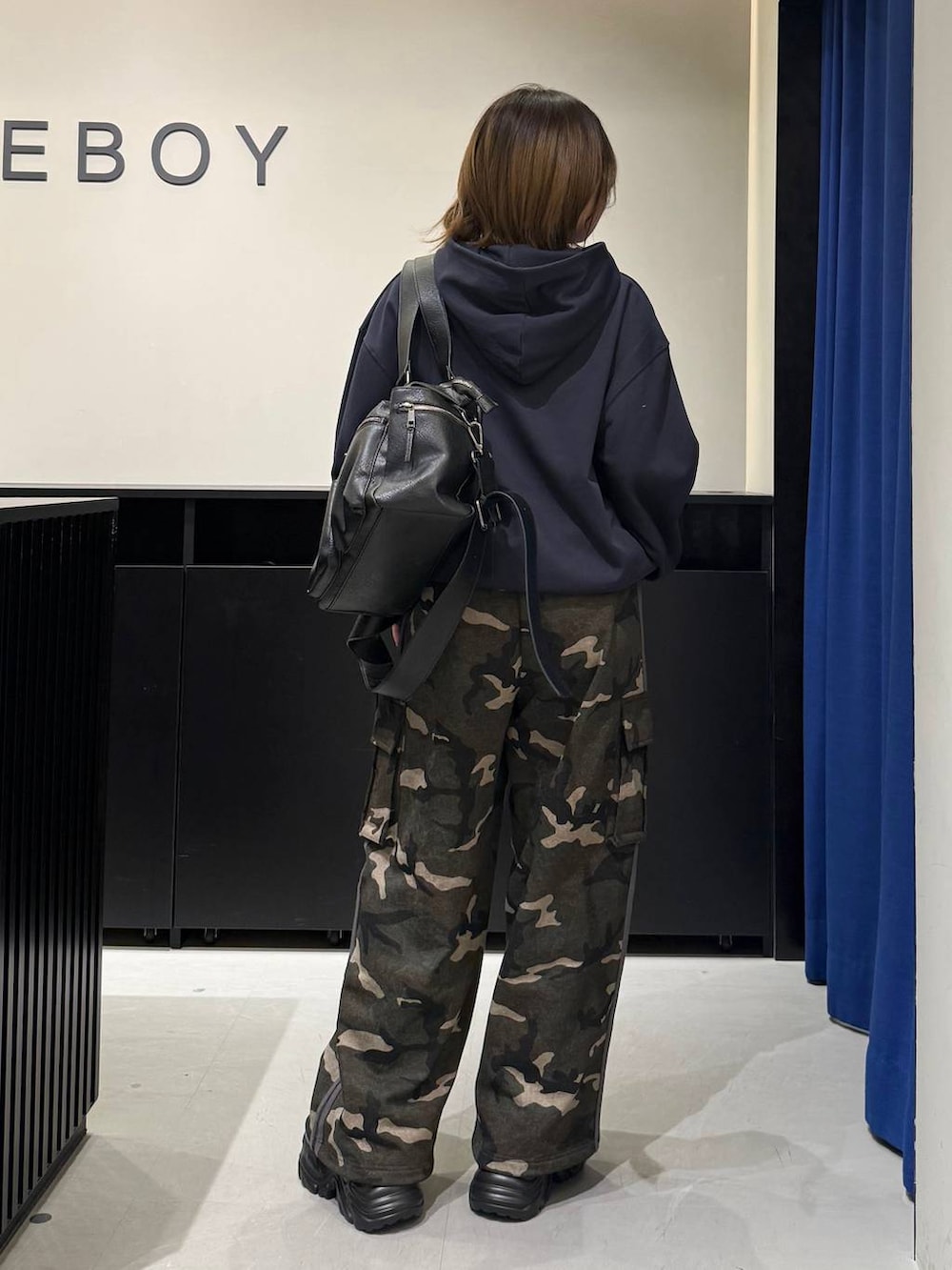 ブラック系のスニーカー、ブラック系のボストンバッグ、グリーン系のスウェットパンツを着用したレディースの冬コーディネートの6枚目の写真