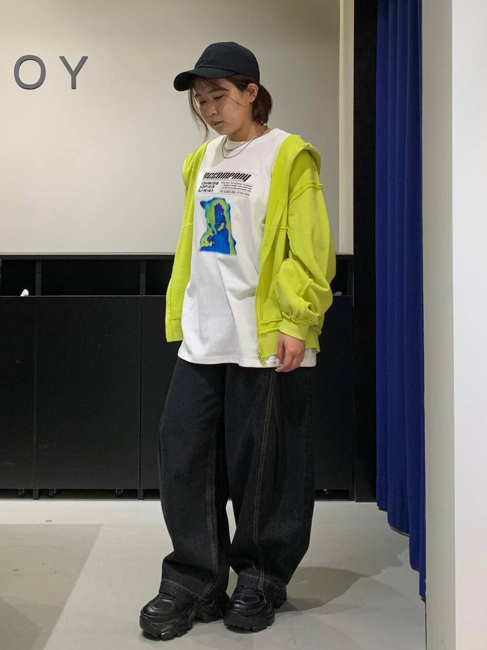 ブラック系のスニーカー、ブラック系のデニムパンツ、ホワイト系のTシャツ/カットソーを着用したレディースの秋コーディネートの7枚目の写真