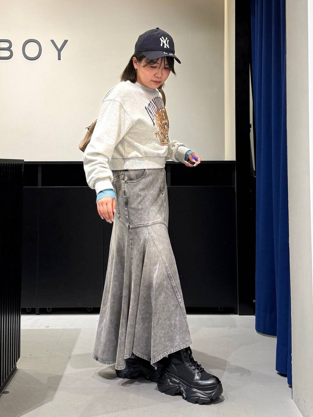 ブラック系のブーツ、イエロー系のボストンバッグ、グレー系のスウェットを着用したレディースの冬コーディネートの3枚目の写真