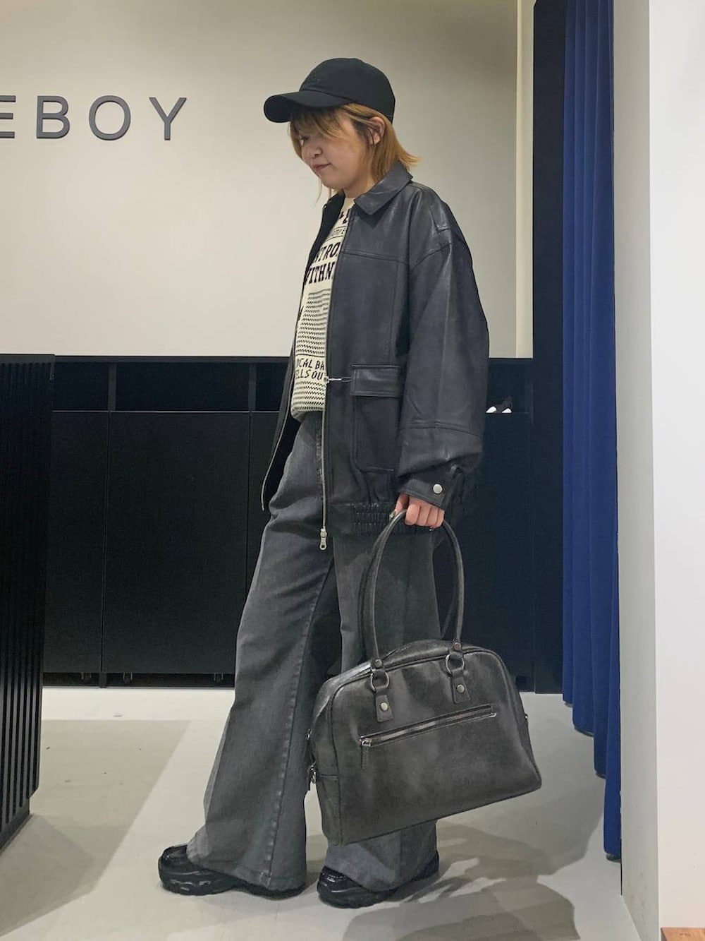 ブラック系のボストンバッグ、ブラック系のブルゾン、ブラック系のローファーを着用したレディースの冬コーディネートの7枚目の写真