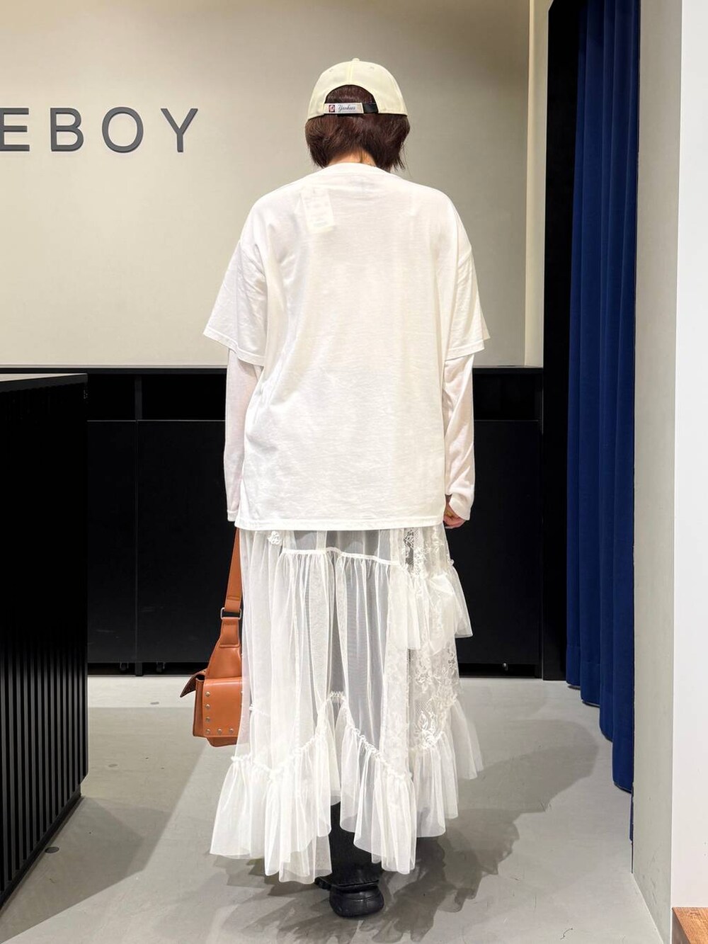 グレー系のサンダル、ブラック系のデニムパンツ、ブラウン系のショルダーバッグを着用したレディースの夏コーディネートの5枚目の写真