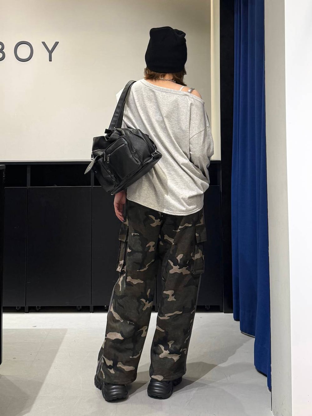 ブラック系のスニーカー、ホワイト系のキャミソール、ブラック系のショルダーバッグを着用したレディースの冬コーディネートの5枚目の写真