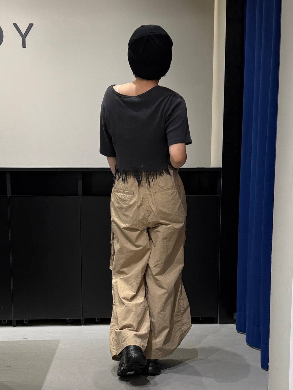 ブラック系のスニーカー、ブラック系のTシャツ/カットソー、ベージュ系のカーゴパンツを着用したレディースの夏コーディネートの4枚目の写真