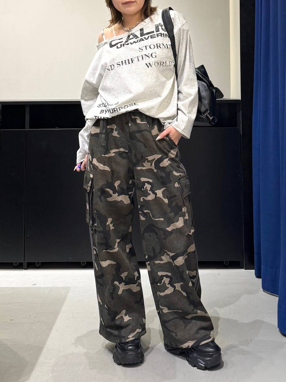 ブラック系のスニーカー、ホワイト系のキャミソール、ブラック系のショルダーバッグを着用したレディースの冬コーディネートの2枚目の写真