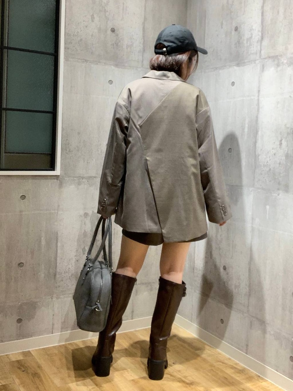 グレー系のボストンバッグ、ブラウン系のテーラードジャケット、ホワイト系のニット/セーターを着用したレディースの秋コーディネートの5枚目の写真