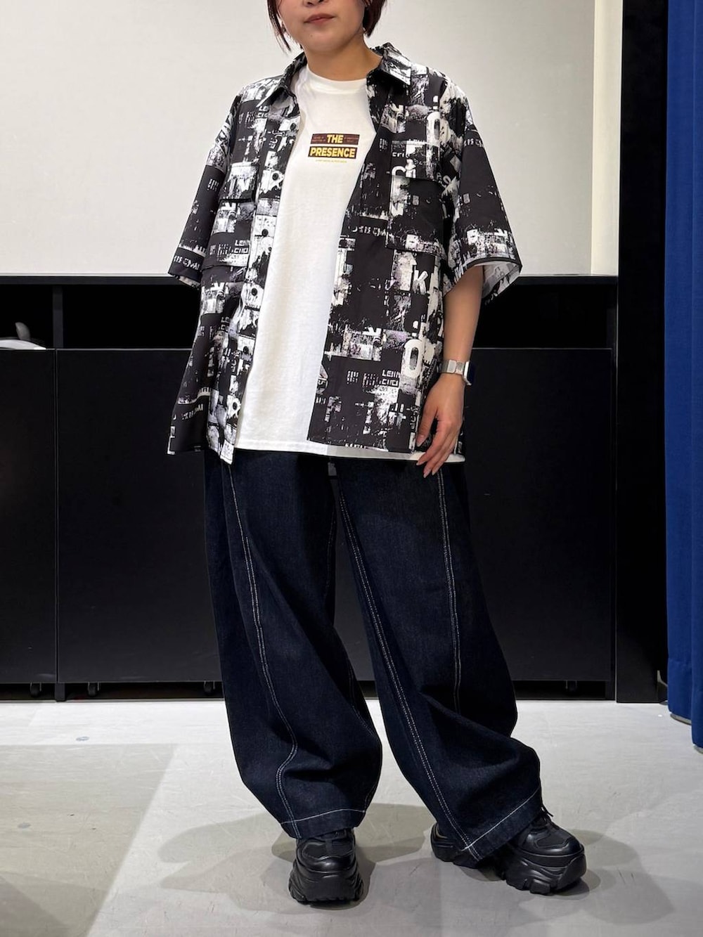 ブラック系のスニーカー、ホワイト系のTシャツ/カットソー、ブラック系のシャツ/ブラウスを着用したレディースの夏コーディネートの2枚目の写真