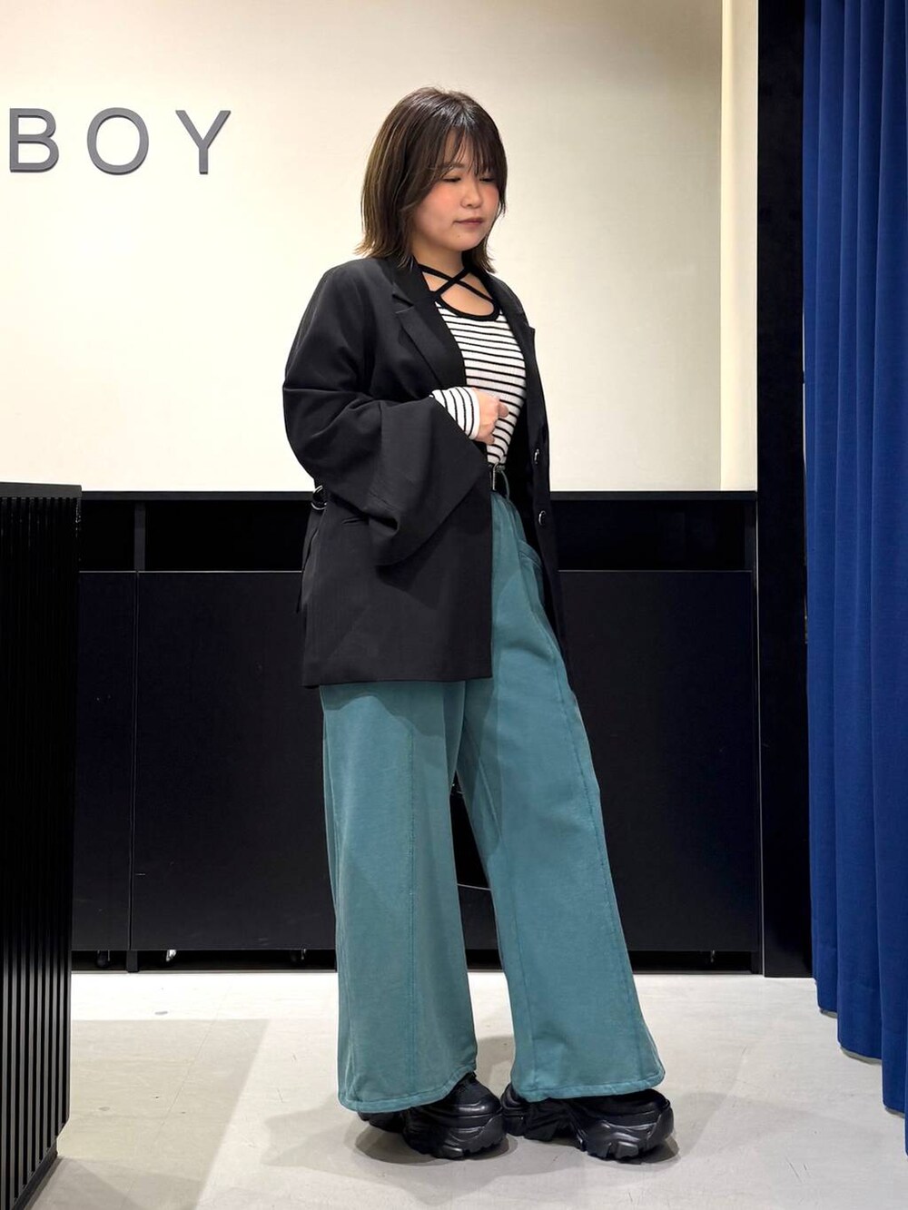 ブラック系のスニーカー、ホワイト系のニット/セーター、ブラック系のテーラードジャケットを着用したレディースの冬コーディネートの3枚目の写真