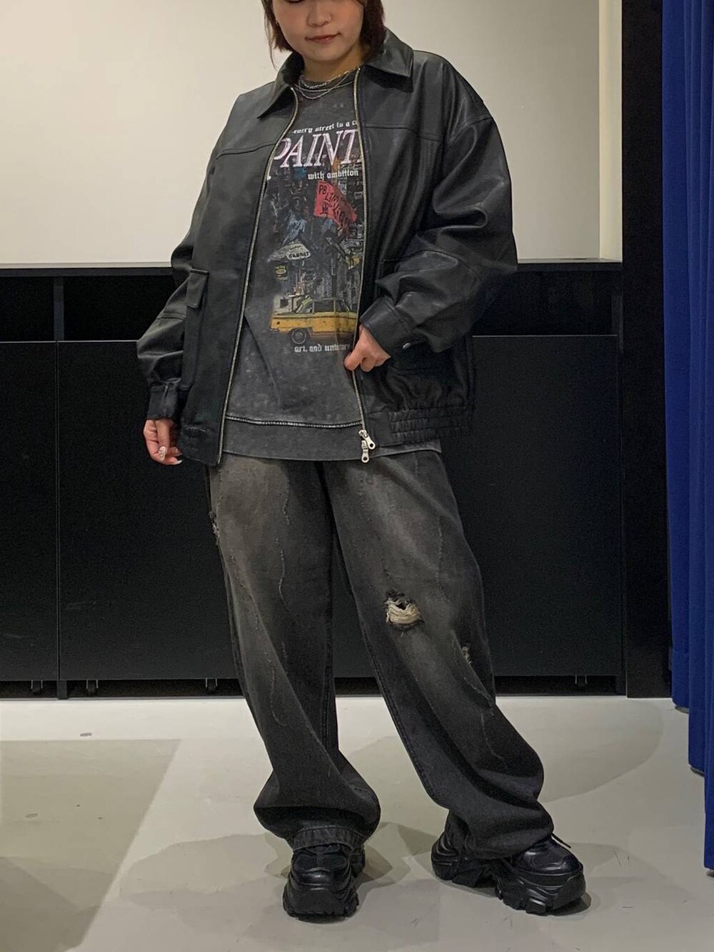 ブラック系のスニーカー、ブラック系のデニムパンツ、ブラック系のブルゾンを着用したレディースの秋コーディネートの2枚目の写真