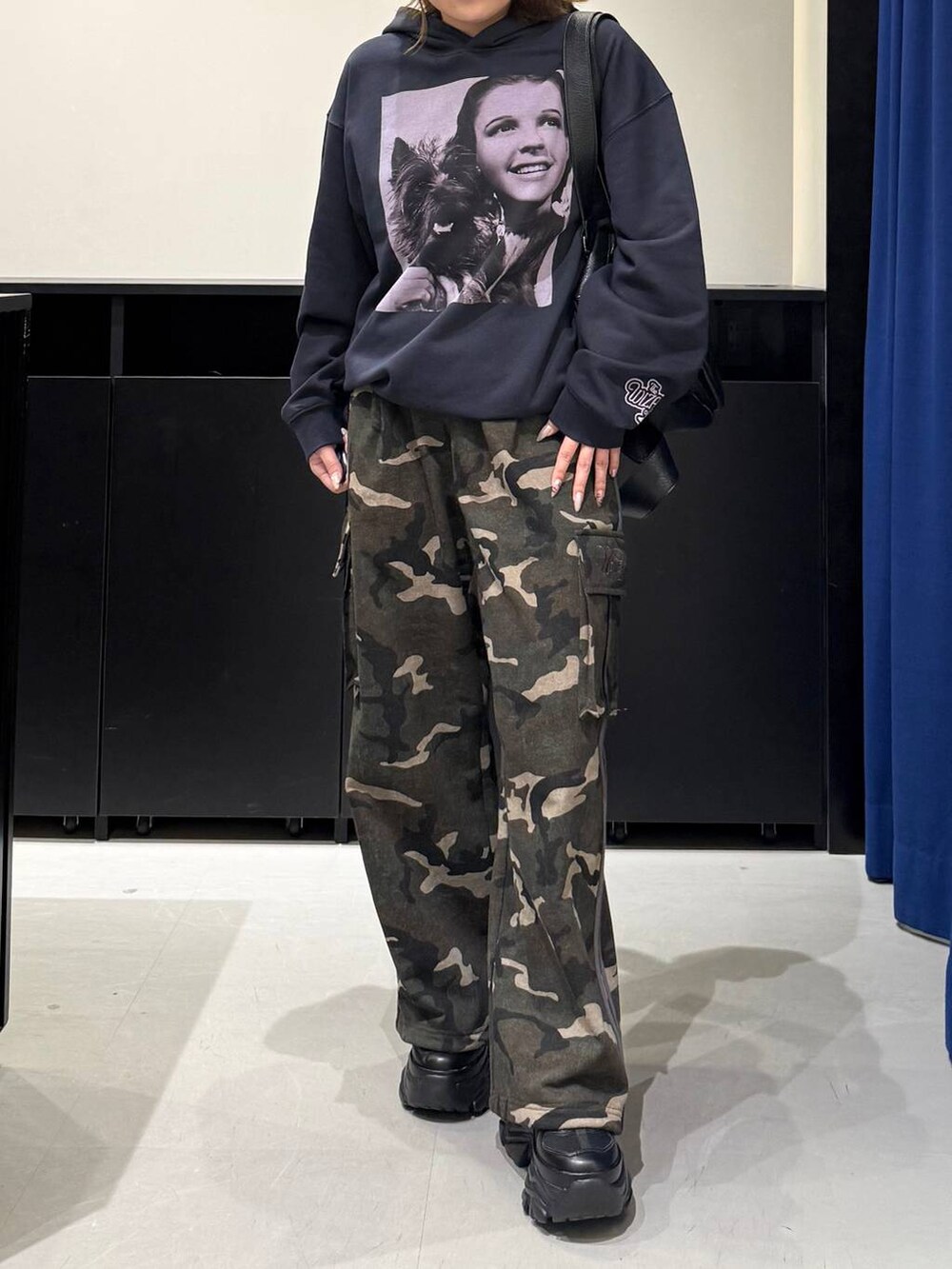 ブラック系のスニーカー、ブラック系のボストンバッグ、グリーン系のスウェットパンツを着用したレディースの冬コーディネートの2枚目の写真