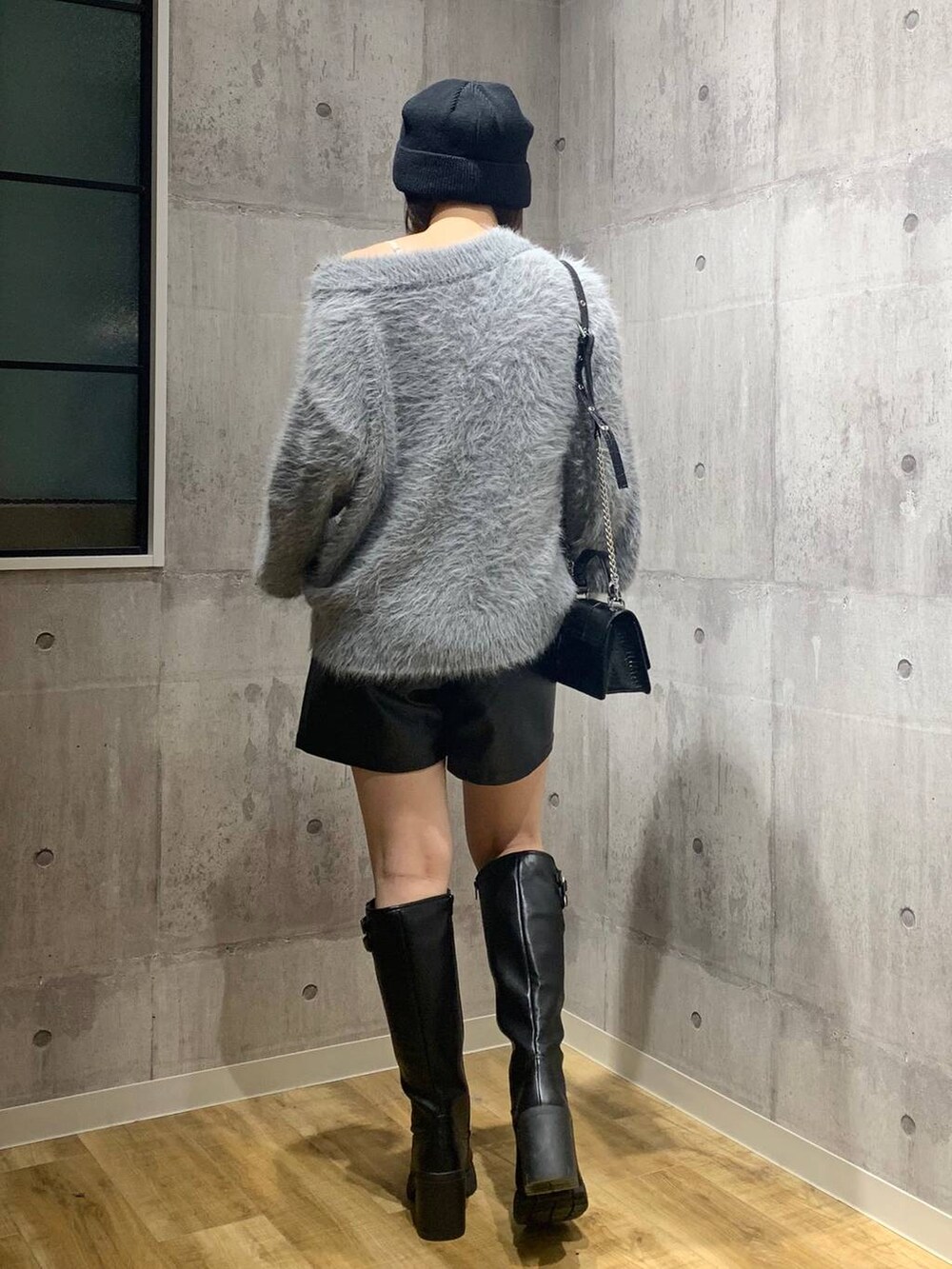 ブラック系のブーツ、ブラック系のハンドバッグ、グレー系のニット/セーターを着用したレディースの秋コーディネートの5枚目の写真