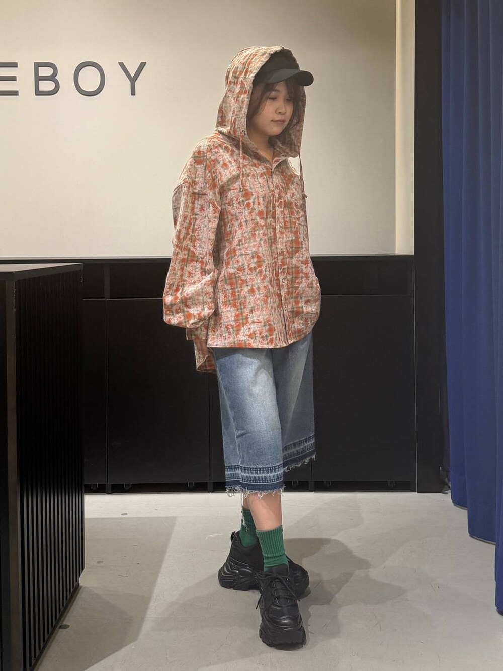 ブラック系のスニーカー、ブルー系のデニムパンツ、オレンジ系のシャツ/ブラウスを着用したレディースの夏コーディネートの3枚目の写真