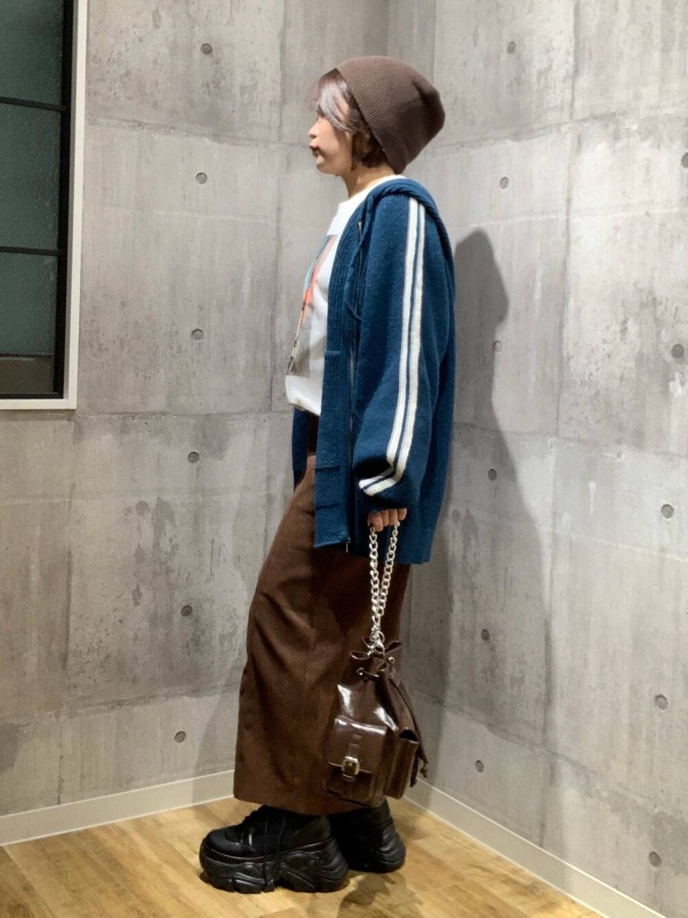 ブラック系のブーツ、ブラウン系のショルダーバッグ、ホワイト系のTシャツ/カットソーを着用したレディースの秋コーディネートの6枚目の写真