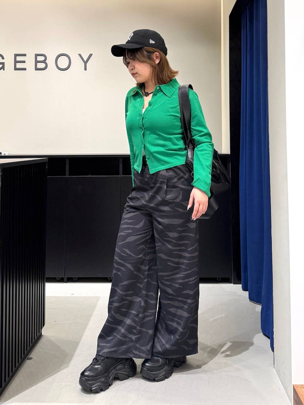 ブラック系のスニーカー、ホワイト系のキャミソール、ブラック系のボストンバッグを着用したレディースの冬コーディネートの7枚目の写真