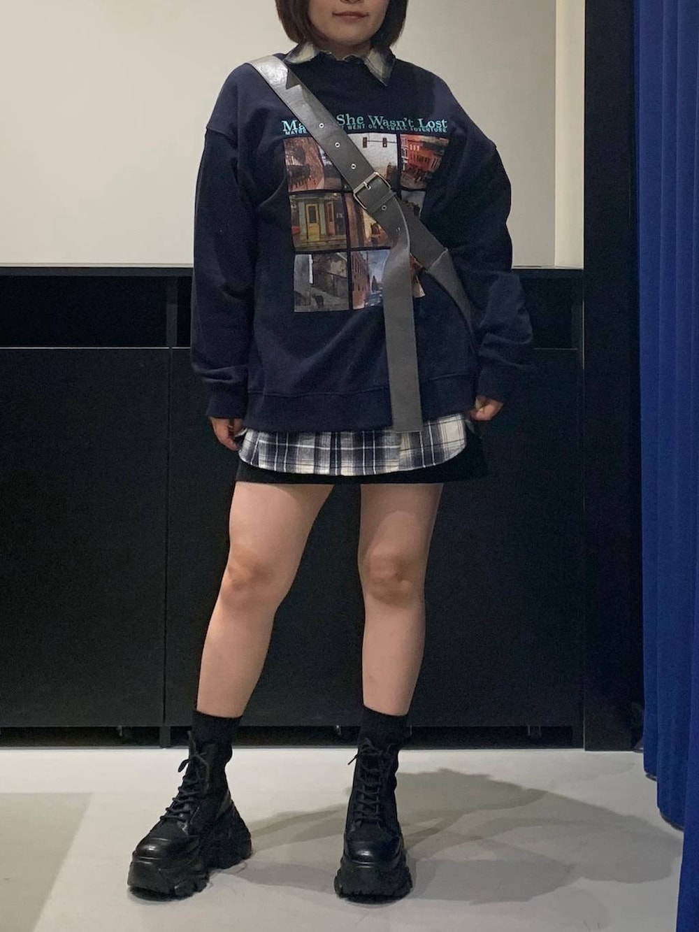 ブラック系のブーツ、グレー系のショルダーバッグ、ブラック系のスカートを着用したレディースの秋コーディネートの2枚目の写真