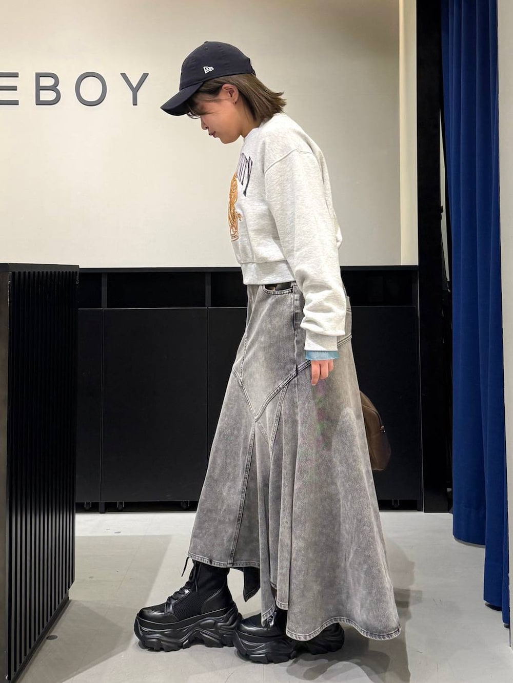 ブラック系のブーツ、イエロー系のボストンバッグ、グレー系のスウェットを着用したレディースの冬コーディネートの5枚目の写真