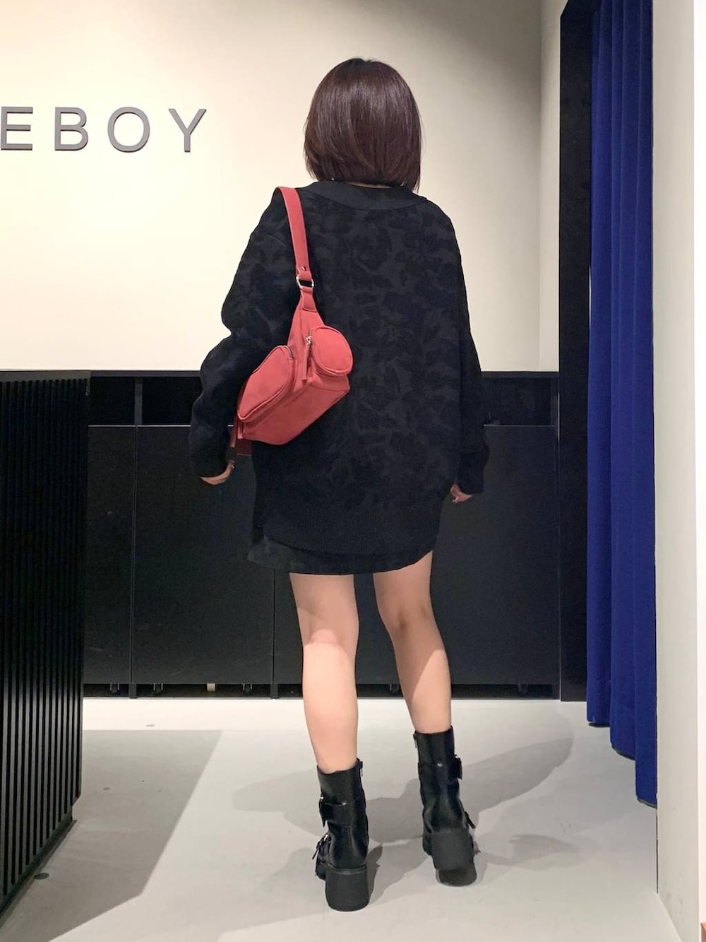 シルバー系のTシャツ/カットソー、ブラック系のスカート、ブラック系のブーツを着用したレディースの秋コーディネートの5枚目の写真