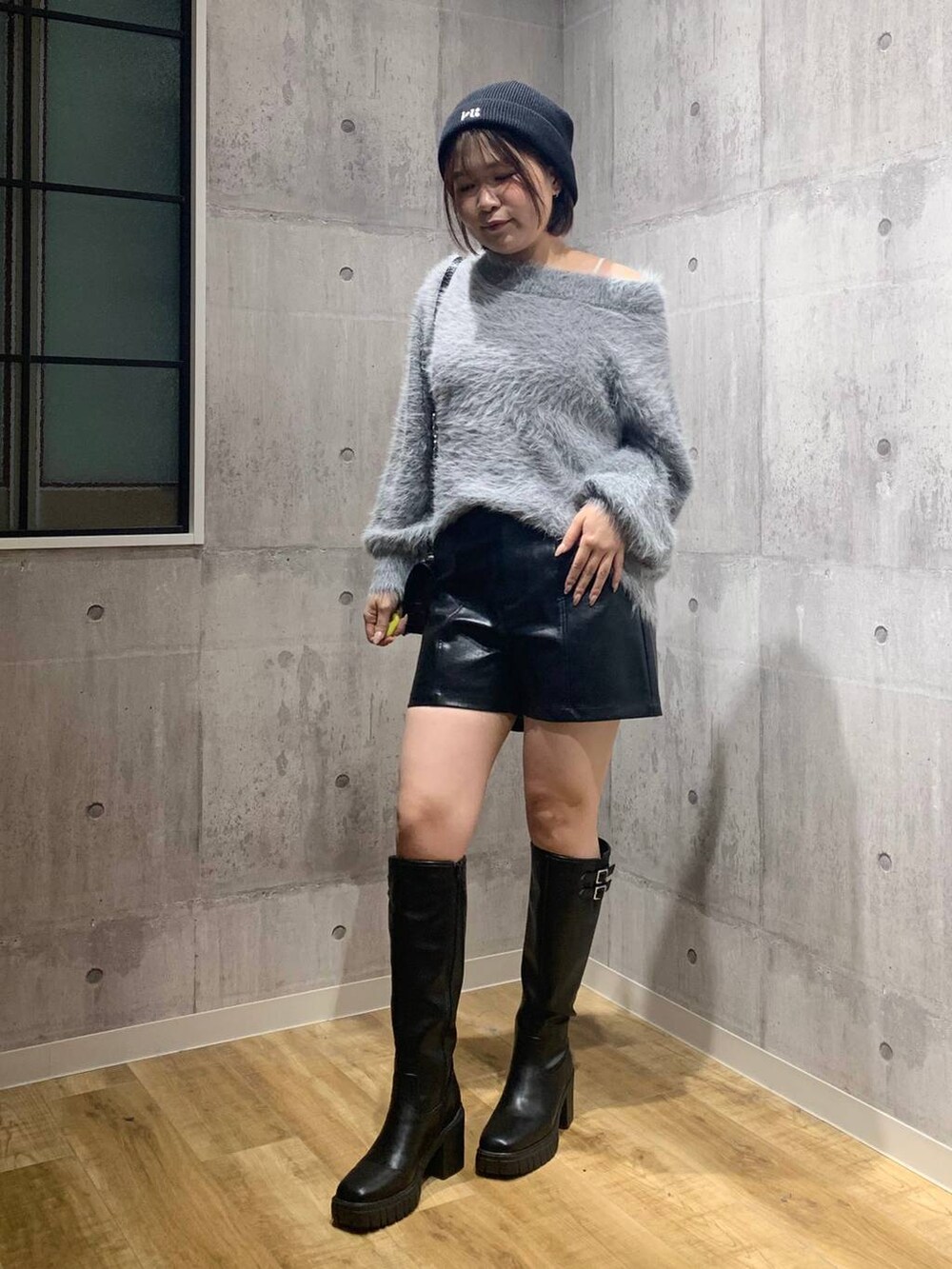 ブラック系のブーツ、ブラック系のハンドバッグ、グレー系のニット/セーターを着用したレディースの秋コーディネートの7枚目の写真