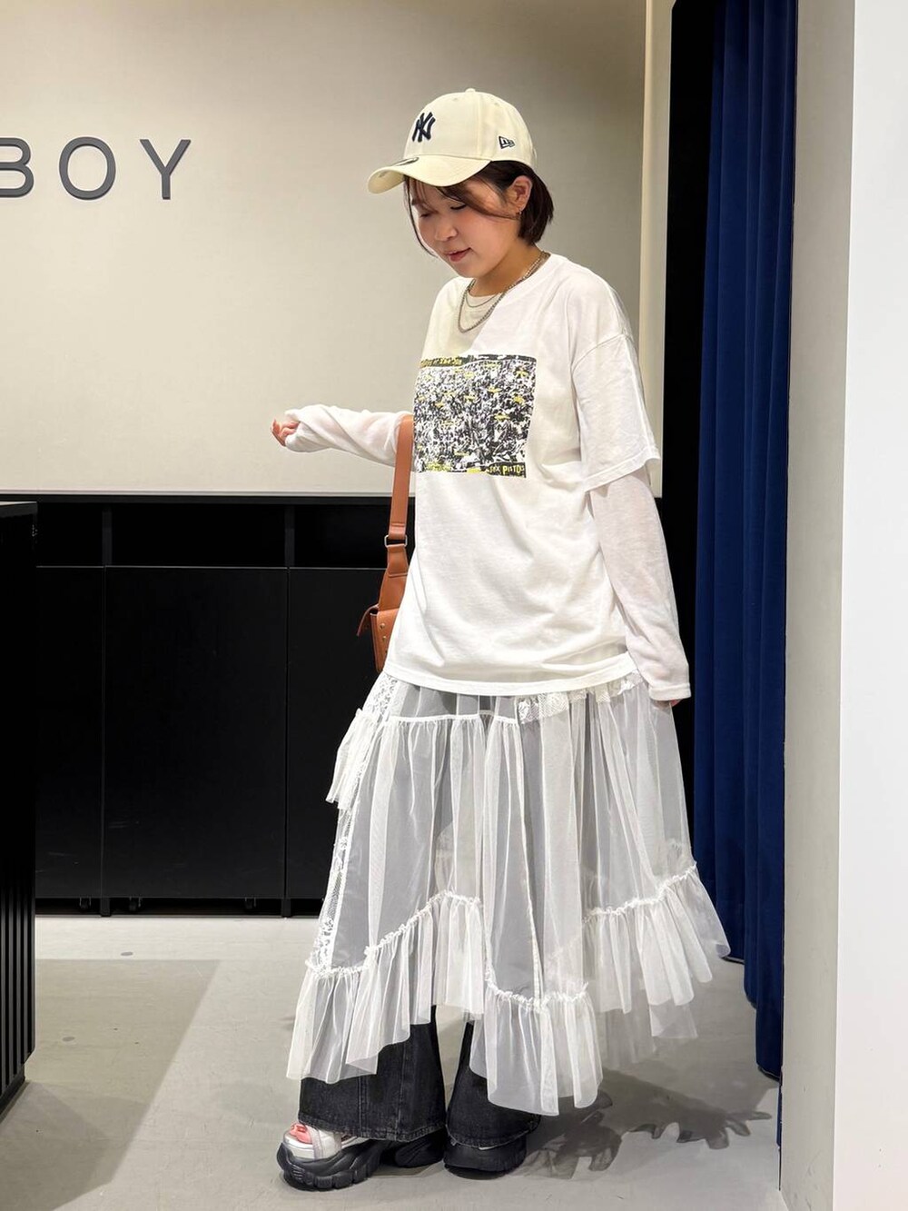 グレー系のサンダル、ブラック系のデニムパンツ、ブラウン系のショルダーバッグを着用したレディースの夏コーディネートの7枚目の写真