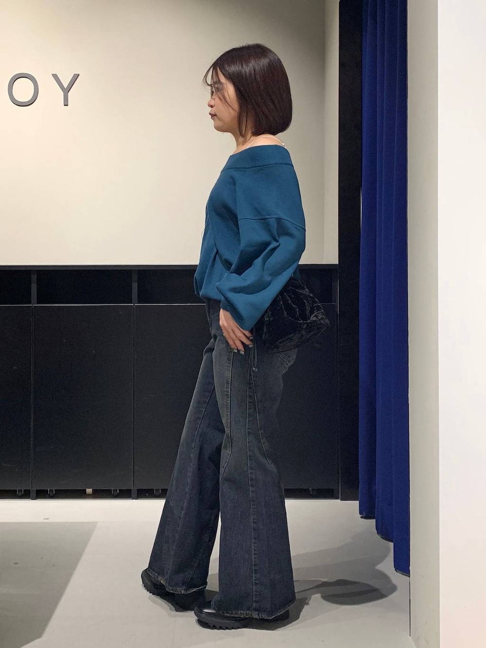 ホワイト系のキャミソール、ブルー系のデニムパンツ、グリーン系のニット/セーターを着用したレディースの秋コーディネートの6枚目の写真