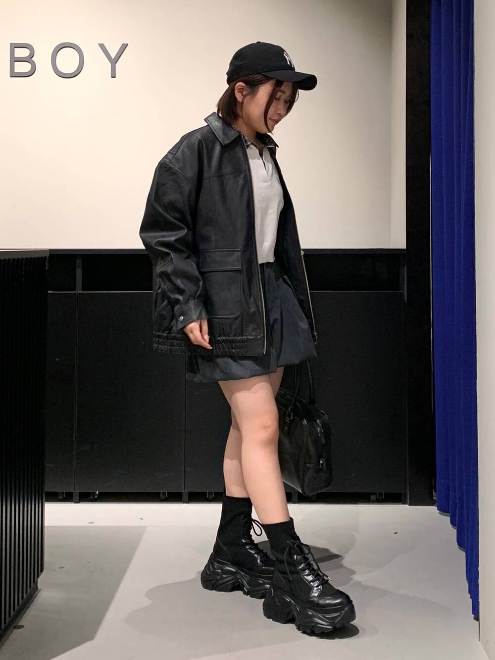 ブラック系のブーツ、ブラック系のボストンバッグ、ブラック系のブルゾンを着用したレディースの冬コーディネートの3枚目の写真