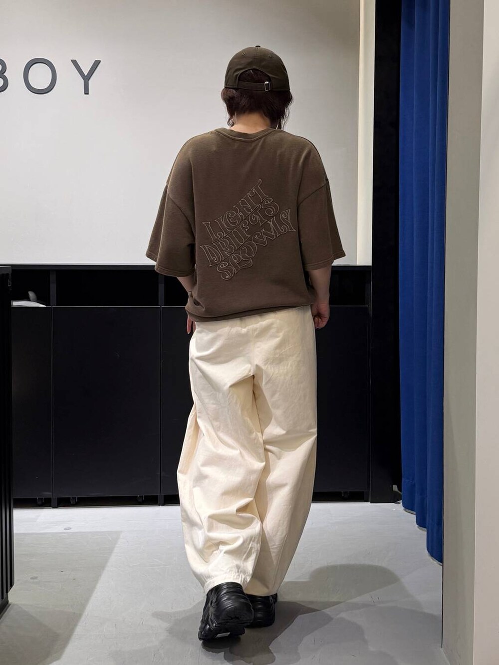 ブラック系のスニーカー、ベージュ系のその他パンツ、ブラウン系のTシャツ/カットソーを着用したレディースの夏コーディネートの5枚目の写真