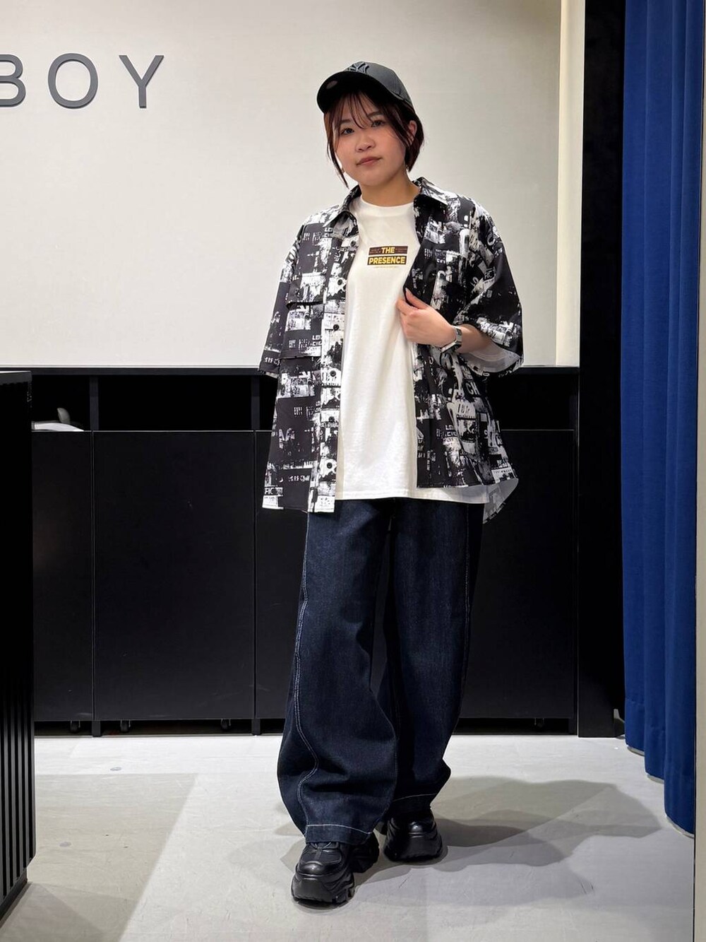 ブラック系のスニーカー、ホワイト系のTシャツ/カットソー、ブラック系のシャツ/ブラウスを着用したレディースの夏コーディネートの3枚目の写真