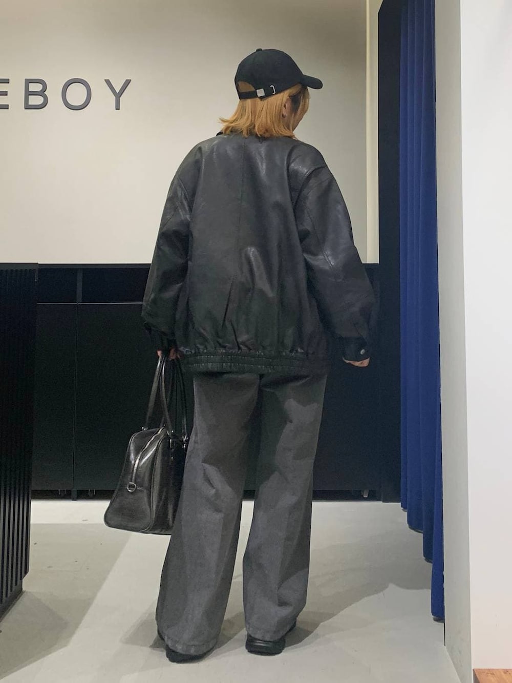 ブラック系のボストンバッグ、ブラック系のブルゾン、ブラック系のローファーを着用したレディースの冬コーディネートの5枚目の写真