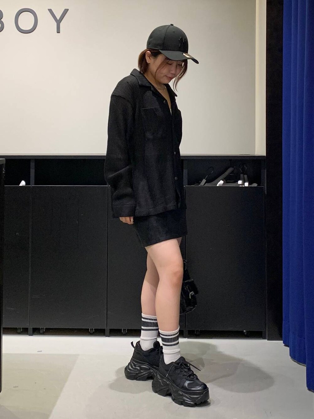 ブラック系のスニーカー、ブラック系のシャツ/ブラウス、ブラック系のショルダーバッグを着用したレディースの秋コーディネートの3枚目の写真