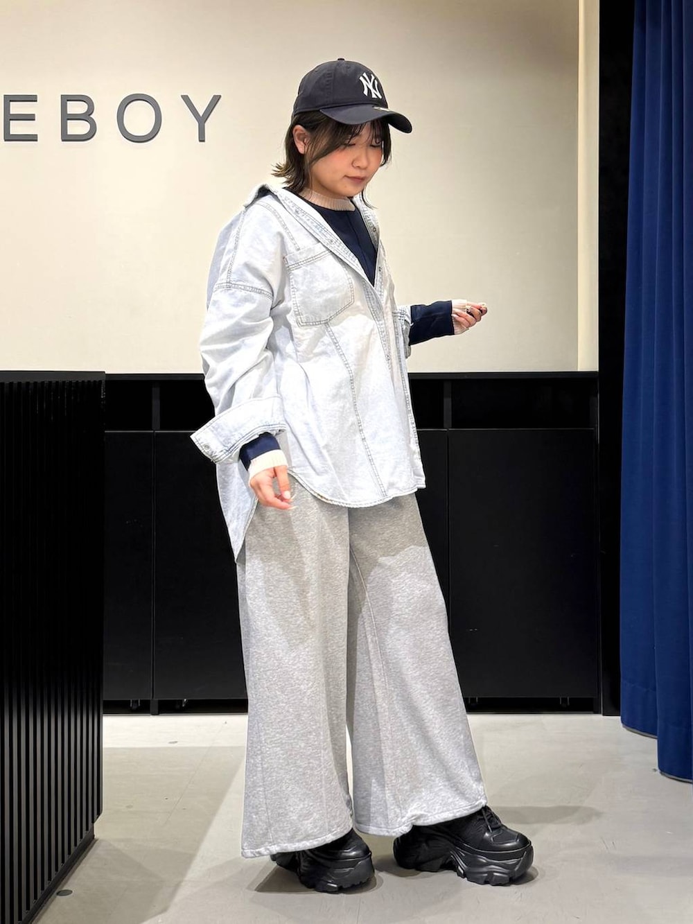 ブラック系のスニーカー、ブラック系のボストンバッグ、ブルー系のシャツ/ブラウスを着用したレディースの冬コーディネートの3枚目の写真